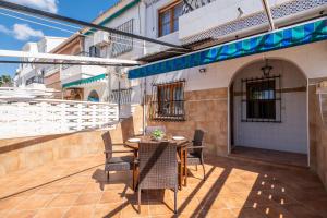 a patio with a table and chairs and a building at Casa Calma in Santa Pola