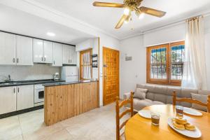a kitchen and living room with a table and a couch at Casa Calma in Santa Pola
