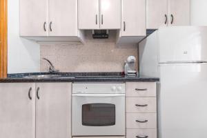 a kitchen with white cabinets and a white oven at Casa Calma in Santa Pola +11 photos