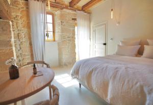een slaapkamer met een bed, een tafel en een raam bij MAISON LOU PIADE Sarlat Your Luxury Farm Hôtel & Confidential place to stay in Sarlat in Sarlat-la-Canéda