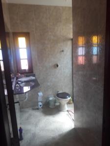 ein Badezimmer mit Dusche, Toilette und Waschbecken in der Unterkunft Casa Alto Padrão Casa Laranja in Praia Sêca