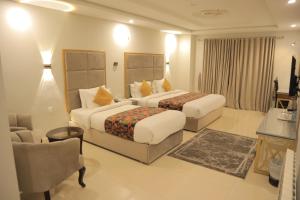 穆里Destination Hotel Murree的有两张床和一把椅子的酒店房间