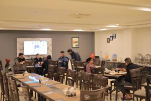 穆里Destination Hotel Murree的一群人坐在餐厅的桌子旁