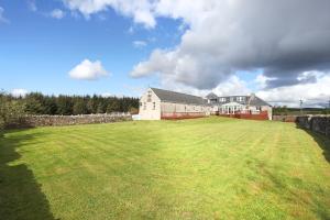 a large yard with a house and a large field at JOIVY Greenknowes Estate with Hot Tub and Bar - Farmhouse and Lodge in Kelty