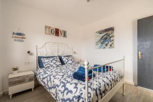 a bedroom with a bed with blue and white sheets at Brisa Marina Ocean View in Antigua +21 photos