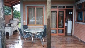 eine Terrasse mit Tisch und Stühlen auf einer Veranda in der Unterkunft Casa Quinta do Paiol in São Bento do Sapucaí + 19 Fotos