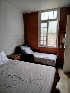 zwei Betten in einem Zimmer mit Fenster in der Unterkunft Casa Quinta do Paiol in São Bento do Sapucaí