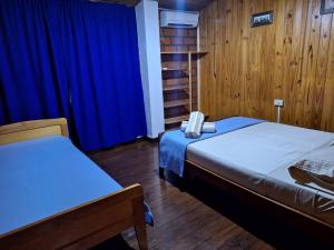 a room with two beds and a blue curtain at La casona in Puerto Iguazú