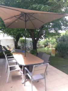 a wooden table and chairs with an umbrella at Calme, familiale ,charmante in Castries