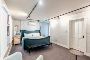 a bedroom with a bed with a green headboard at Yellow Room at Grand Maloney in Key West