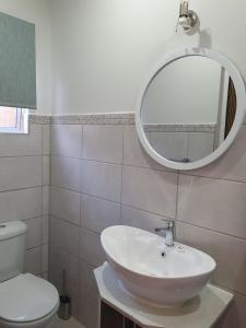 un bagno con un lavandino bianco e uno specchio di Willow's Corner-Just like home! a Durban