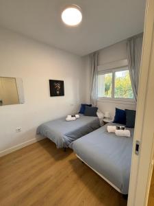 a bedroom with two beds and a window at Cozy Apt 3BR, 5min to beach, 20min Almeria center in Retamar