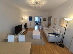 a living room with a white couch and a tv at Spacious and bright apartment for 4 in Helsinki