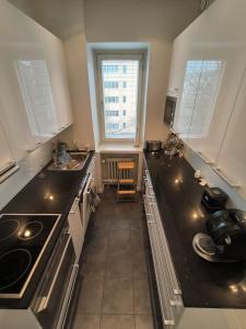 a kitchen with a black counter top and two windows at Spacious and bright apartment for 4 in Helsinki