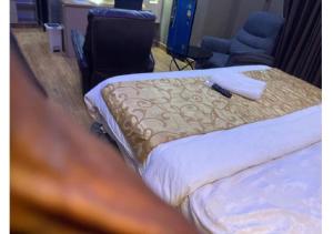 two beds in a hotel room with a towel on them at Grand Diamond Hotels & Suites LTD in Owerri