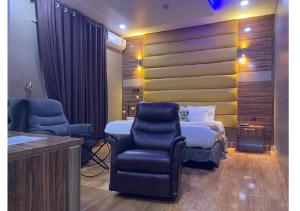a hotel room with a bed and a chair at Grand Diamond Hotels & Suites LTD in Owerri