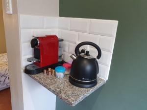 a tea kettle on a counter next to a red microwave at Willow's Corner-Just like home! in Durban
