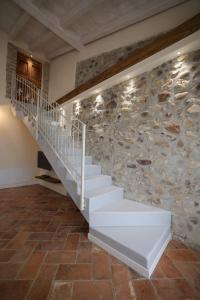 een trap in een kamer met een stenen muur bij Bouganville Dimore in Desenzano del Garda