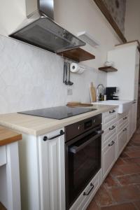 een keuken met witte kasten en een kookplaat oven bij Bouganville Dimore in Desenzano del Garda +31 foto's