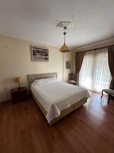 a bedroom with a white bed and a wooden floor at Luxury Villa Neighboring Oludeniz in Fethiye