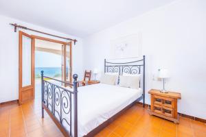 a bedroom with a bed and a window with the ocean at Villa Can Torrens de Alcudia in Alcudia +37 photos