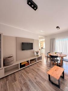 ein Wohnzimmer mit einem Tisch und einem Fernseher an der Wand in der Unterkunft Los Molinos, confort, estilo y privacidad en Barrio Estación in Villa Mercedes