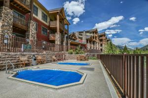 a patio with a blue pool in front of a building at Hidden River Lodge 5981 by SummitCove Lodging in Keystone