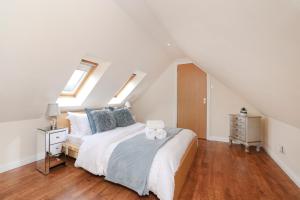 a bedroom with a large bed with blue pillows at JOIVY Greenknowes Lodge with Hot Tub and Wood Burning Stove in Kelty