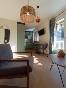 un soggiorno con un divano e un tavolo di Meublé 3 étoiles - PISCINE- BALCON - TENNIS ad Aix-les-Bains