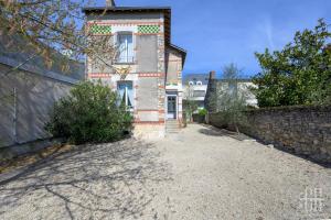 an external view of a house with a stone wall at Maison familiale bords de Loire avec jardin et 3 Chambres in Saint-Cyr-sur-Loire
