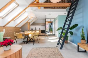 a room with a dining table and a ladder at Apartamenty Dwie Sosny in Junoszyno