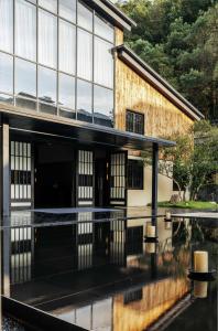 uma vista externa de um edifício com reflexo na água em 景德镇行山世外东篱院民宿 em Xianghu
