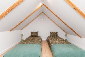 two beds in a room in a attic at Apartamenty Dwie Sosny in Junoszyno