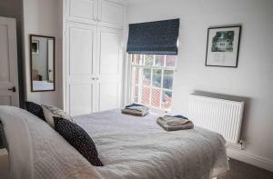 ein Schlafzimmer mit einem Bett mit zwei Handtüchern darauf in der Unterkunft Hope Cottage - Charming 3 bedroom house, Southwold in Southwold