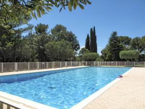 a swimming pool with a fence and trees at La Pierrerie Bambou in Tourtour