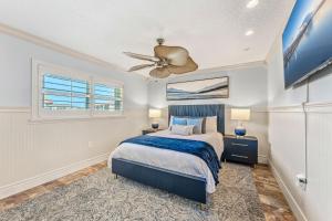 a bedroom with a bed and a ceiling fan at Casa De Olas - Waterfront Luxe Home - Heated Pool - Game Room - Boat Lift - Minutes to Beach in Cocoa Beach +82 photos