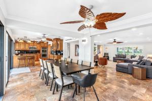 a dining room and living room with a table and chairs at Casa De Olas - Waterfront Luxe Home - Heated Pool - Game Room - Boat Lift - Minutes to Beach in Cocoa Beach