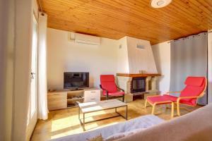 sala de estar con 2 sillas rojas y TV en Le Van Gogh 3 chambres 4 lits, en Tournefeuille