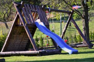a playground with a blue slide in the grass at Domček u Alina in Žiar