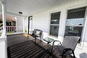 a porch with two chairs and a bench on a house at Hannahs Haven in Lima