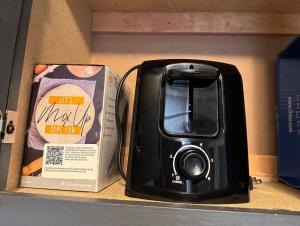 a black toaster sitting on a shelf next to a box at Hannahs Haven in Lima