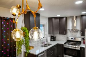 a kitchen with three glassoons hanging from a chandelier at 5 Bedroom Home 10 Min Drive To Downtown in Denver