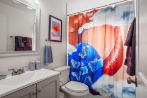 a bathroom with a toilet and a shower curtain at 5 Bedroom Home 10 Min Drive To Downtown in Denver +31 photos
