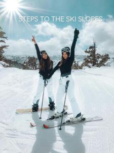 two women standing on skis in the snow at Rocky Mountain Retreat Steps to Slopes with Hot Tub and Spectacular Views in Winter Park