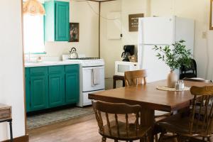 a kitchen with green cabinets and a wooden table at Beaver Creek Cabin 1 in Strasburg