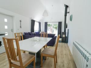 a dining room and living room with a white table and chairs at Cornel Clud in Cemaes Bay +13 photos