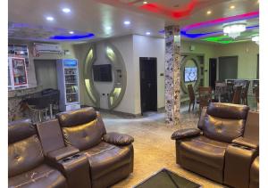 a living room with leather furniture and a bar at Grand Diamond Hotels & Suites LTD in Owerri