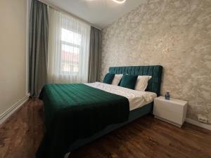 a bedroom with a green bed and a window at Urban Waves with 2 bedrooms and terace in Constanţa +11 photos