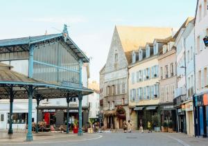 une rue urbaine avec des bâtiments et des gens qui marchent dans la rue dans l'établissement Appart avec terrasse, vue & parking - hyper centre, à Chartres