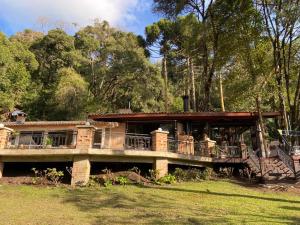 a house with people sitting on the deck at Canto das Águas in Camanducaia